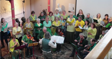Group of singers and musicians dressed in green and yellow