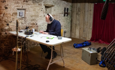 Man wearing headphones, sitting at a desk