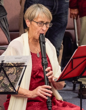 Woman blowing into a large recorder